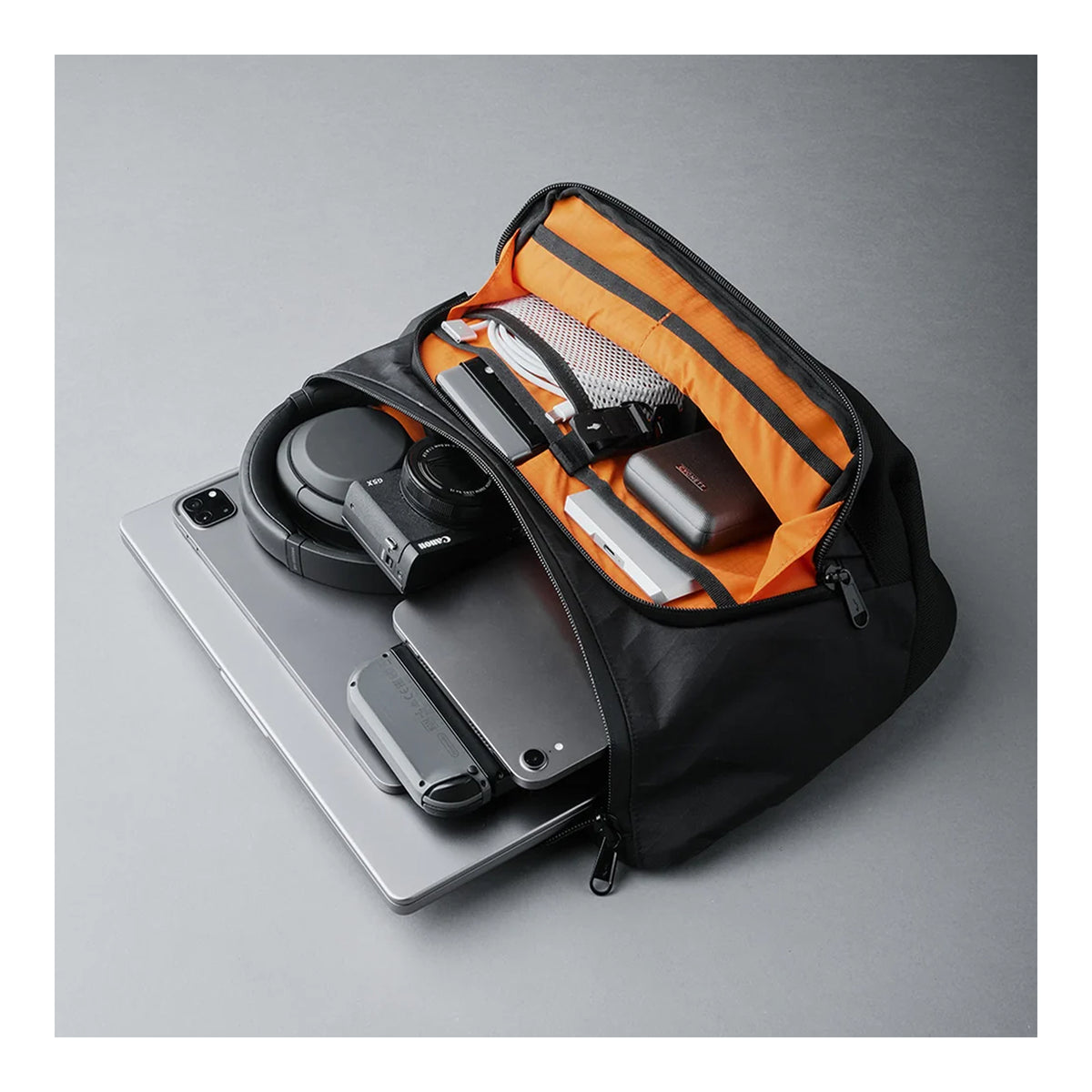 Alpaka Bravo Sling Max V2, розкрита сумка, планшет, навушники, фотоапарат та зовнішній акумулятор всередині