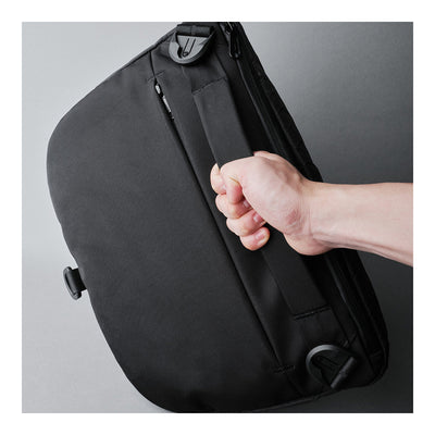 Alpaka Bravo Sling Max V2, сумку тримають за вбудовану ручку зверху, фіксатори ременя по кутах
