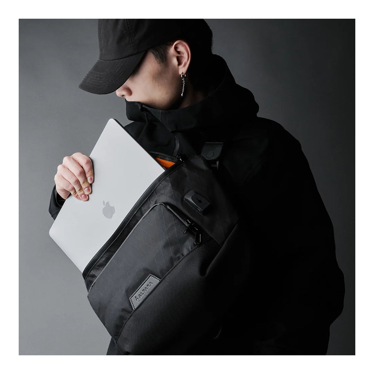 Alpaka Bravo Sling Max V2, ноутбук кладуть у бокове відділення слінга на плечі, бренд-нашивка Alpaka знизу